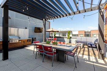 A patio with a table and chairs under a striped awning.